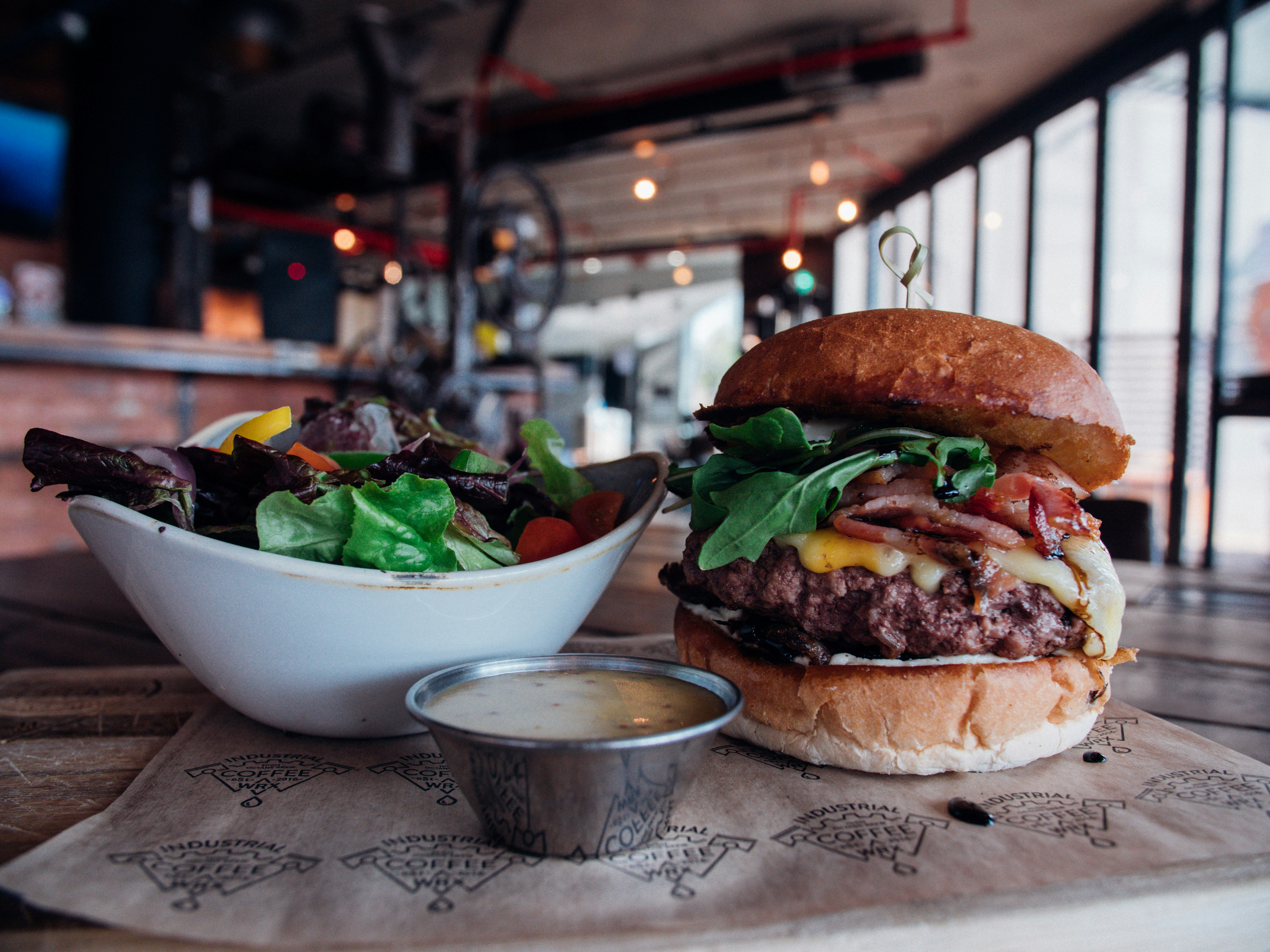 burger with lettuce and tomatoes on white ceramic bowl